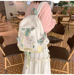 Detail view of nylon backpack with star charm and plush toy in a cozy cafe setting