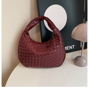 Detailed view of the dark red woven PU leather Hobo handbag on a minimalist table
