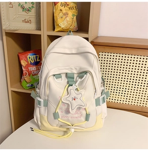Close-up of beige nylon backpack with star pendant and pink astronaut embroidery