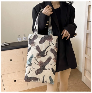 Detail shot of canvas tote bag featuring an elegant crane print and durable handles