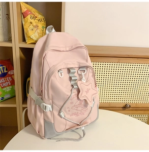Pink nylon backpack detail showing embroidery planet pattern and star pendant