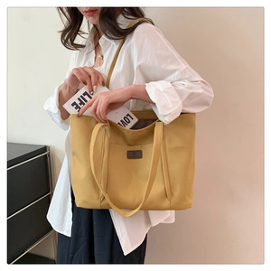 Detail view of bright yellow nylon tote bag showing spacious capacity for books