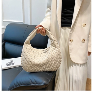 Close-up of ivory woven PU leather hobo handbag featuring a knotted handle detail