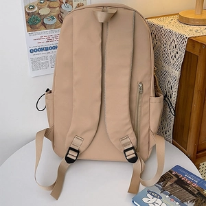 Fashionable beige nylon backpack for women featuring adjustable straps and hidden pockets