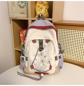 Detail of multi-color nylon backpack with UFO cartoon print and star shaped pendant