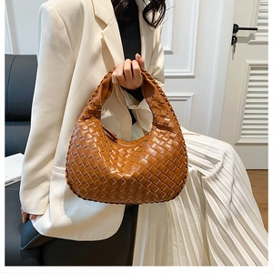 Close-up of caramel brown woven leather hobo bag with a stylish knot handle detail