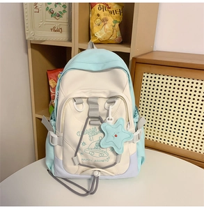 Detail of macaron pastel nylon backpack with UFO graphics and star-shaped pendant