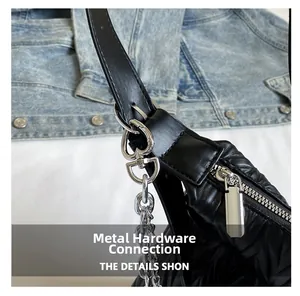 Detail of silver heart-shaped hardware and chain on a black pleated texture PU crossbody bag