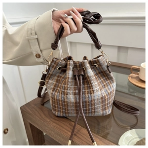 Detailed view of plaid fabric texture and drawstring closure on women bucket bag