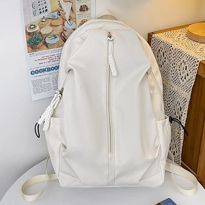 Minimalist beige nylon backpack for women with vertical zipper in a cozy interior setting
