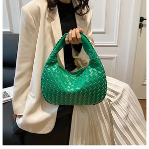Detail of green woven hobo bag with knotted handle and premium leather texture