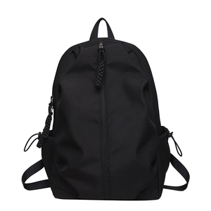 Minimalist black nylon backpack with vertical zipper and woven drawstring accents