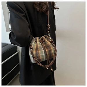 Close-up of vintage wool plaid bucket bag featuring leather drawstring and woven handle