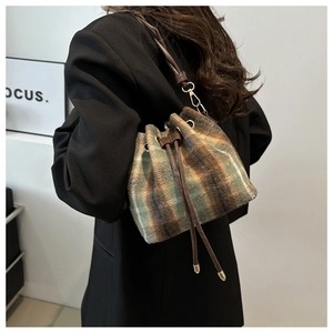 Detail view of retro plaid bucket bag in thick wool fabric with leather straps