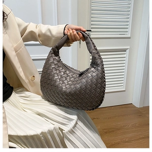 Detailed macro view of the grey Intrecciato woven leather hobo bag held by a model