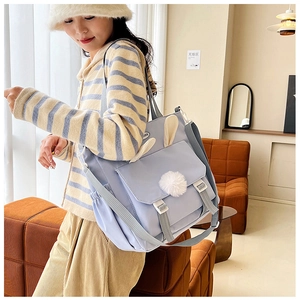Detailed view of light blue nylon crossbody bag with cute rabbit ears and white plush ball