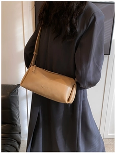 Adjustable strap and zip closure detail on khaki leather cylinder shoulder bag