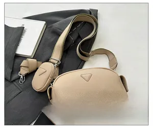 Detailed view of khaki crossbody bag featuring removable coin purse and canvas shoulder strap