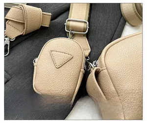 Detail of beige lychee pattern PU leather crossbody bag with triangular coin purse attachment