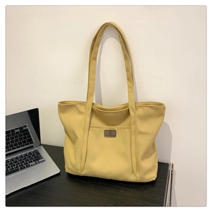 Fashionable ginger yellow canvas tote bag for school or office on a desk