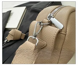 Close-up of premium silver hardware and textured PU leather stitching on beige crossbody bag