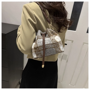 Detail showing plush checkered bucket bag with brown leather drawstring and golden hardware