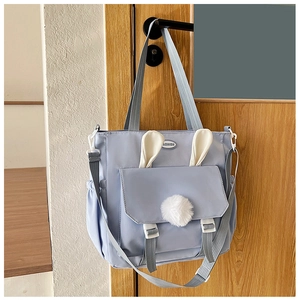 Fashion light blue nylon crossbody bag with cute white 3D bunny ears and pom-pom detail
