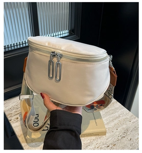 Détail d'un sac bandoulière en nylon blanc avec large sangle jacquard et double fermeture éclair