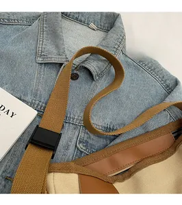Detailed view of the adjustable wide woven shoulder strap on this stylish canvas crossbody bag