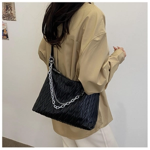 Detail shot of black ruched PU crossbody bag with silver chain straps and wave texture