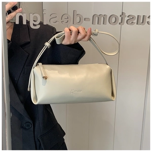 Close-up of beige PU leather shoulder bag with LUKADI logo embossing and thin strap