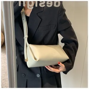 Detail of soft cream PU leather crossbody bag with adjustable strap and gold metal buckle