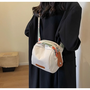 Dettaglio borsa a tracolla bianca con cinturino etnico in jacquard colorato e finiture in pelle