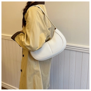 Detail showing white PU leather crossbody bag with pebble grain texture and stitching