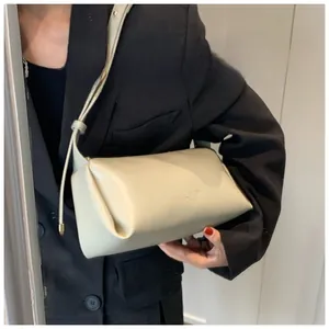 Close-up of beige PU leather crossbody bag featuring minimalist logo and adjustable strap