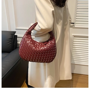 Detail of burgundy woven leather hobo bag with a distinctive knot design on handle