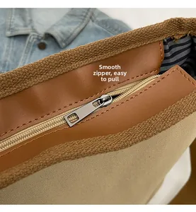 Detail view of the smooth silver zipper and blue striped lining of the PU tote bag