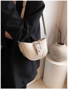 Vue détaillée du sac bandoulière croissant crème avec grande boucle en métal argenté et cuir