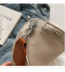 Détail du zip argenté et de la sangle ethnique tissée sur le sac à bandoulière beige