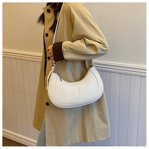 Detail of white crescent crossbody bag in high-quality pebbled leather on model
