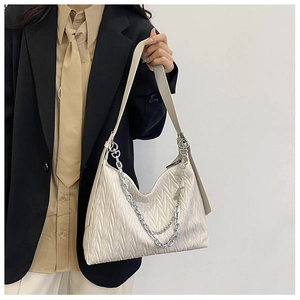 Detail of off-white quilted PU leather crossbody bag with chic silver chain and shoulder strap