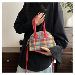 Detail of retro plaid handbag with red leather trim and adjustable crossbody strap