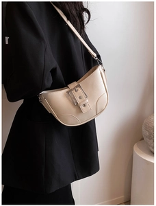 Détail d'un sac hobo beige avec boucle en métal argenté et cuir PU texturé de qualité