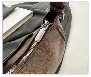 Detailed macro view of smooth silver metal zipper on vintage brown waxed leather bag