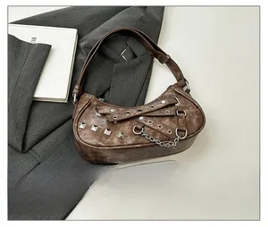 Close-up of vintage brown PU leather bag with metallic rivets and gothic chain details