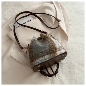 Plaid plush bucket bag with brown leather base and metallic feet for daily outfit