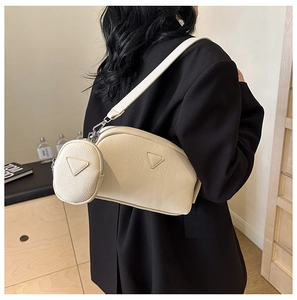 Detail of beige textured PU leather crossbody bag featuring modular pouch and silver hardware