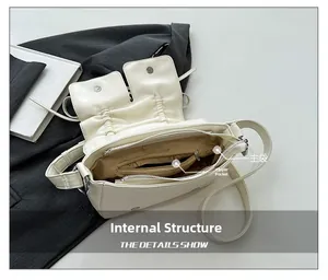 Detail view of the cream pleated shoulder bag interior showing the main pocket and zipper bag