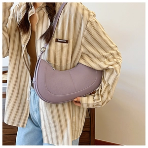 Detailed view of purple lychee pattern crescent shoulder bag on model with stripe shirt