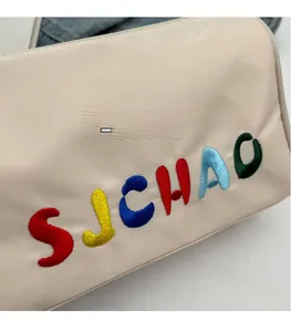 Détail du tissu beige texturé avec broderie 3D colorée SJCHAO et fermeture éclair